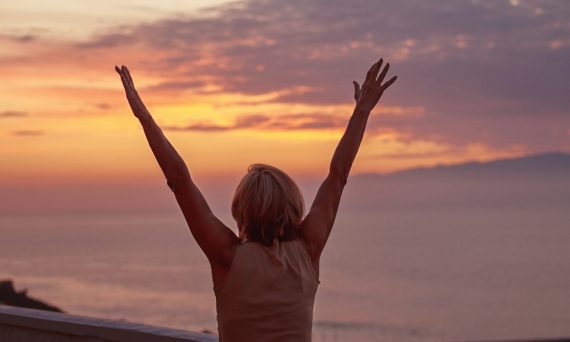 woman in white shirt raising her hands
